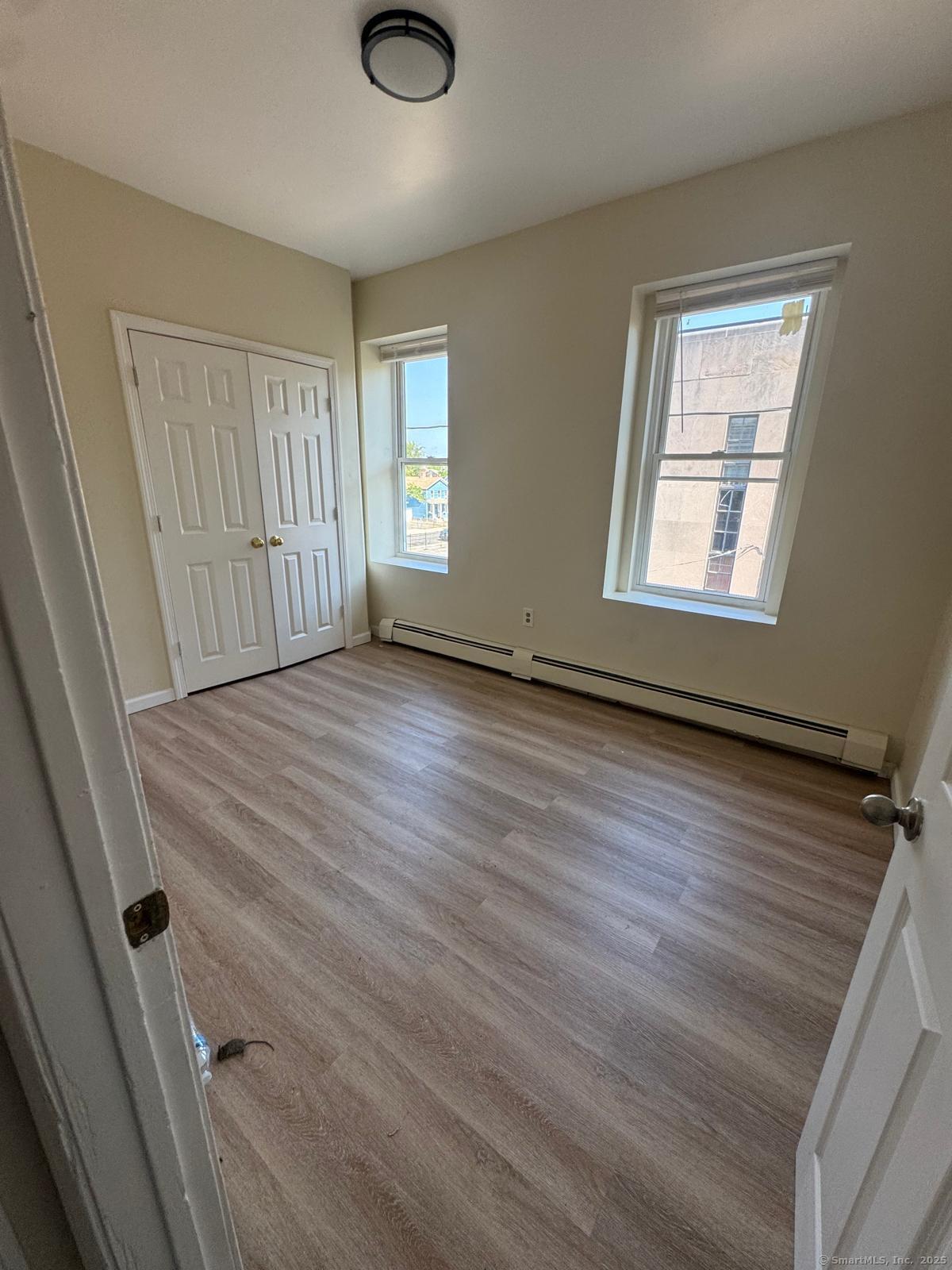1053 East Main Street, Unit 8 Bridgeport, CT 06608 - Photo 3 of 4 a view of an empty room with a window and wooden floor