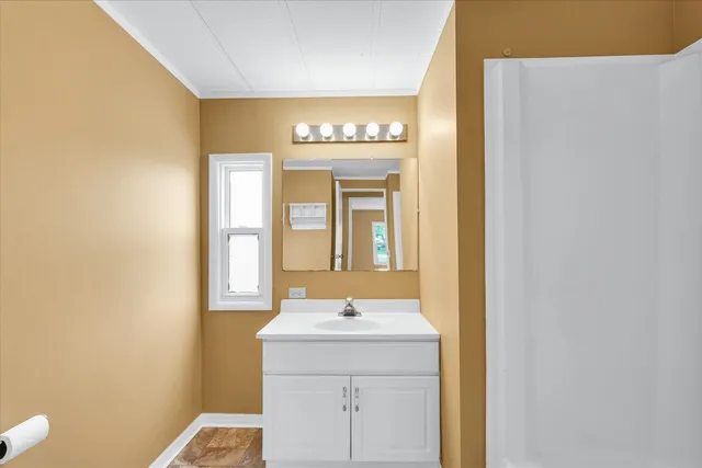 a view of a hallway with wooden floor and closet area