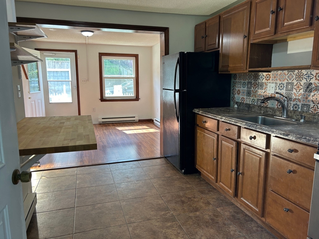 67 Everard Street Worcester, MA 01605 - Photo 2 of 13 a kitchen with stainless steel appliances granite countertop a refrigerator and a sink