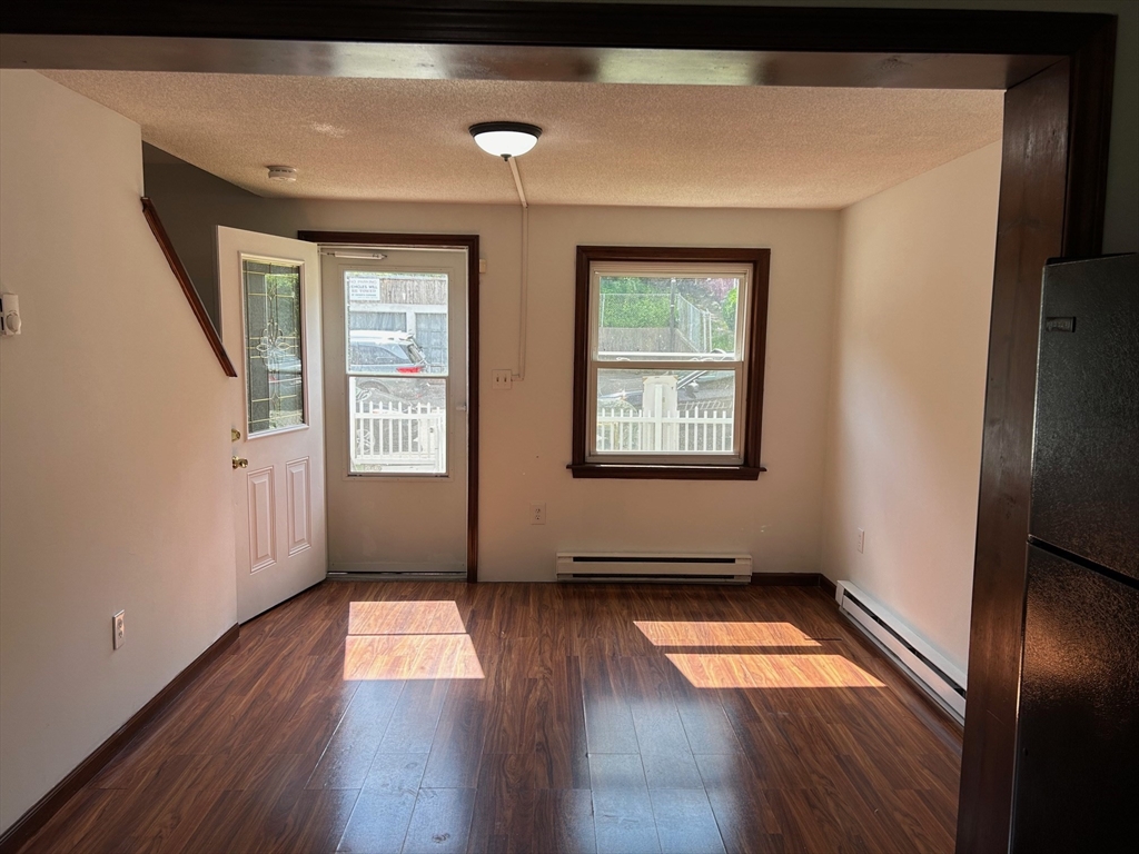 67 Everard Street Worcester, MA 01605 - Photo 5 of 13 an empty room with wooden floor and windows