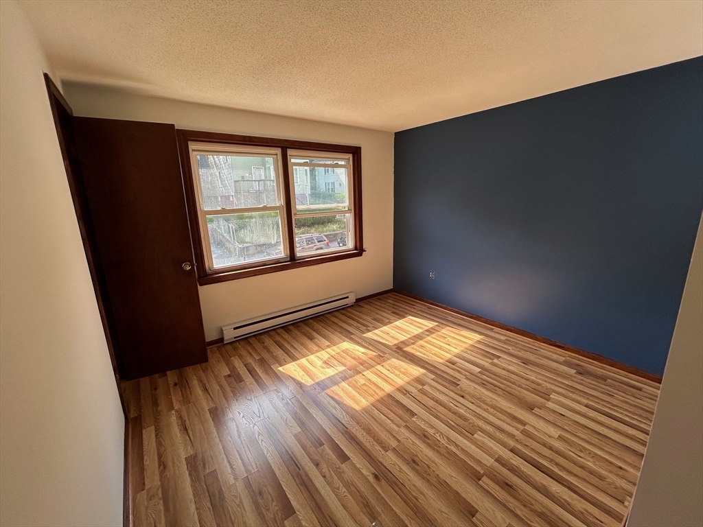 67 Everard Street Worcester, MA 01605 - Photo 7 of 13 a view of an empty room with wooden floor and a window
