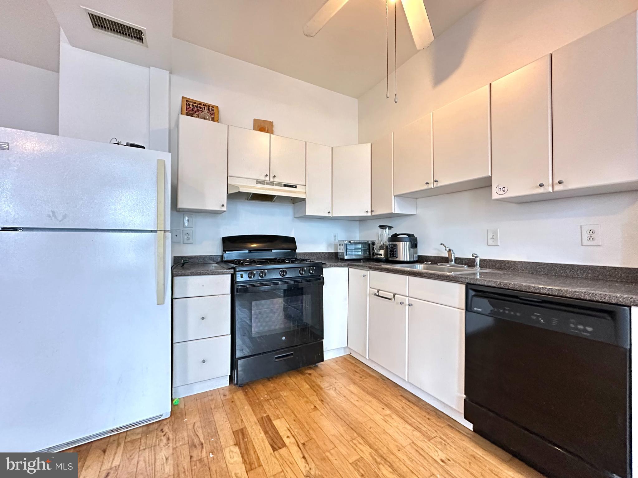 1214 North 5th Street, Unit 2 Philadelphia, PA 19122 - Photo 6 of 17 a kitchen with stainless steel appliances granite countertop a refrigerator sink and stove
