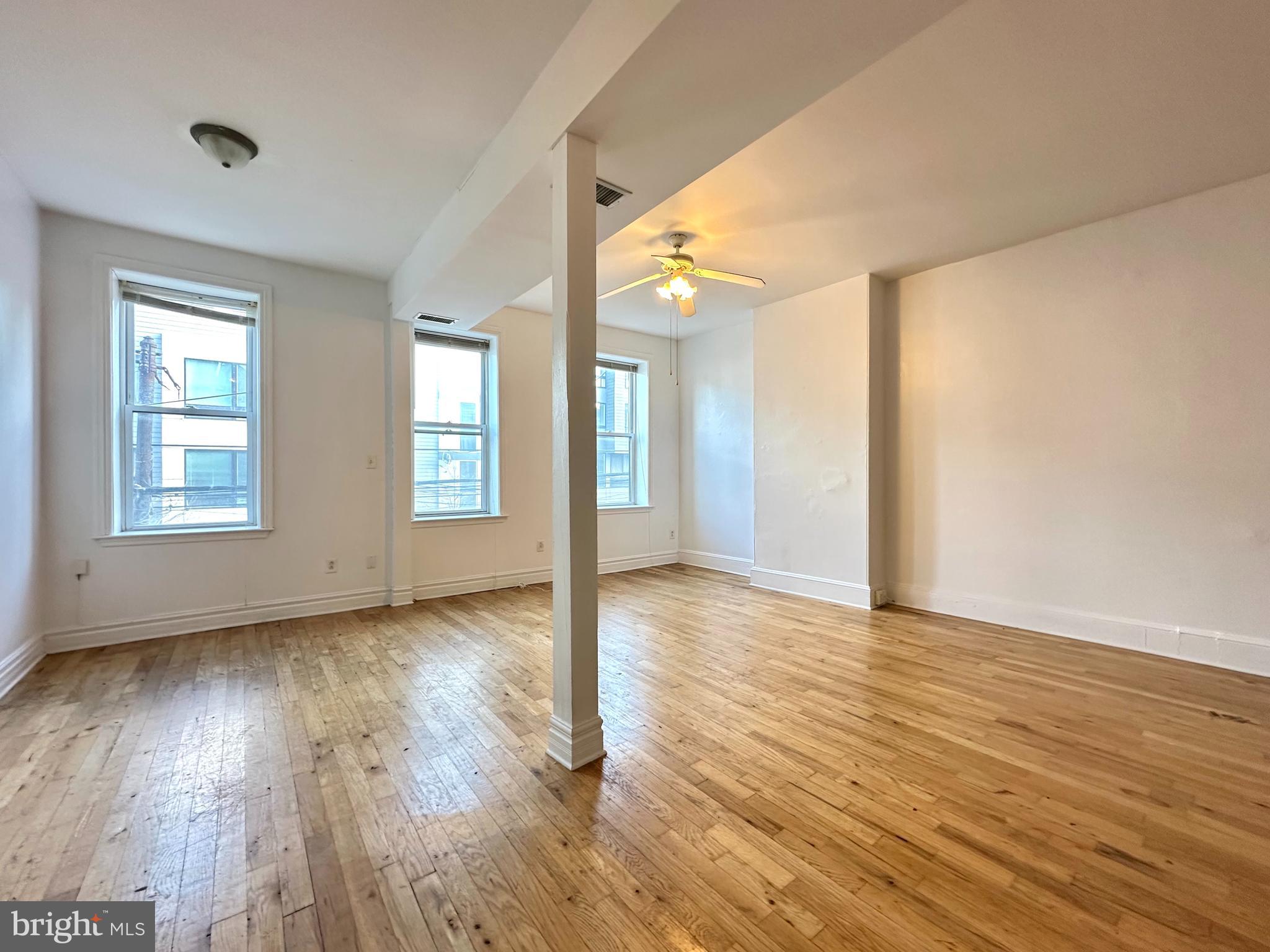 1214 North 5th Street, Unit 2 Philadelphia, PA 19122 - Photo 7 of 17 an empty room with wooden floor and windows