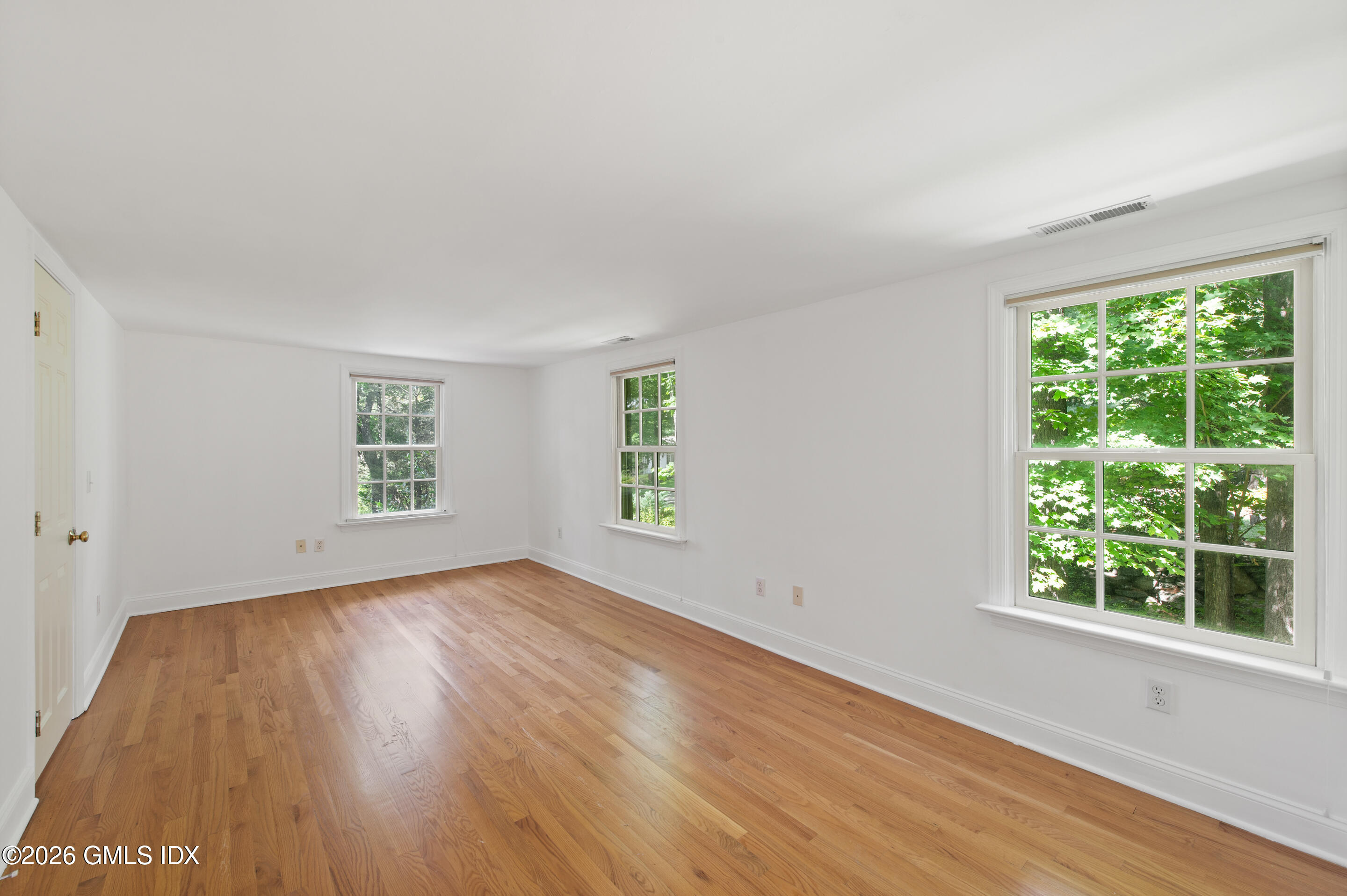 122 Round Hill Road Greenwich, CT 06831 - Photo 34 of 37 an empty room with wooden floor and windows