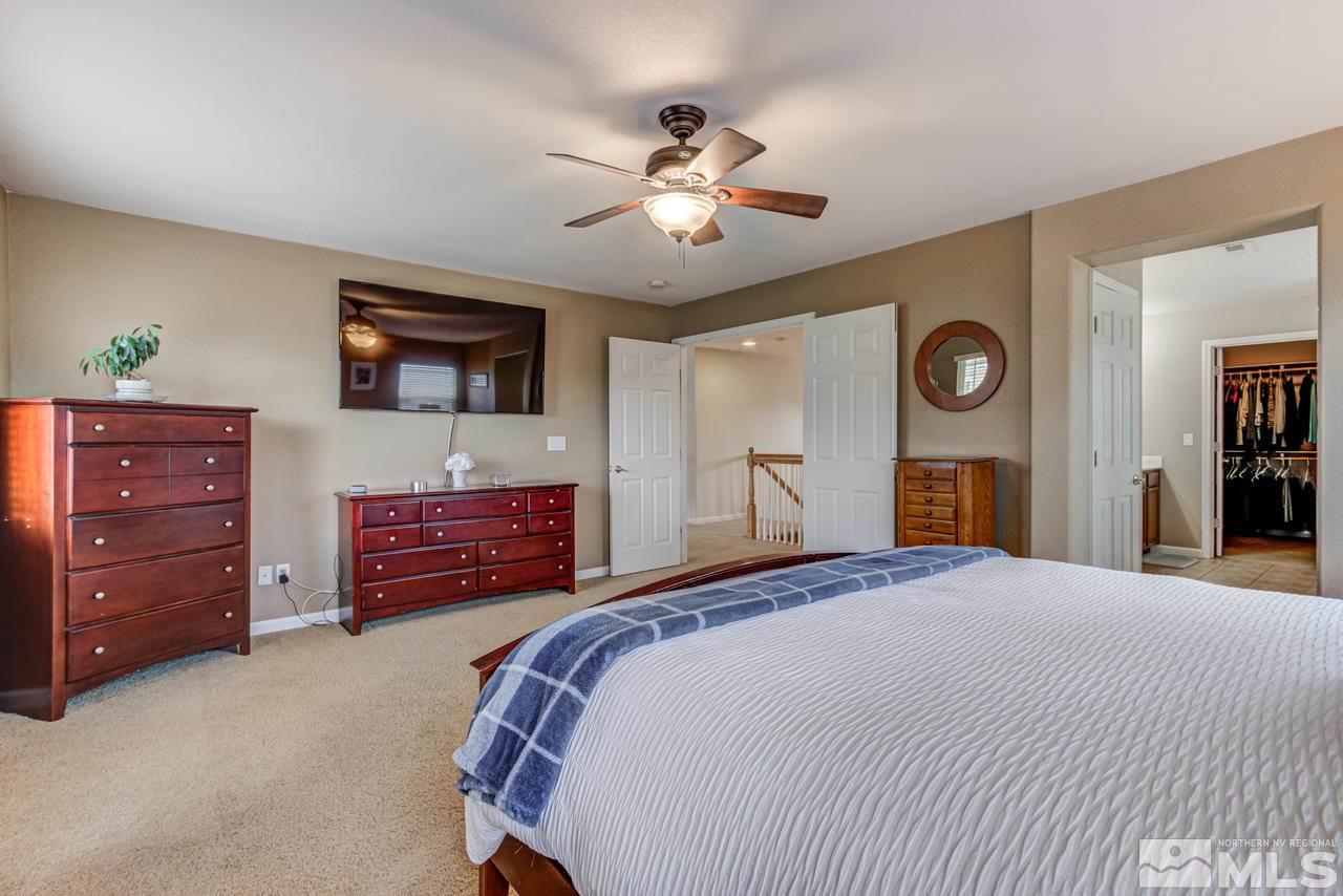 8921 Sorcha Street Reno, NV 89506 - Photo 21 of 35 a bedroom with a bed and a chandelier