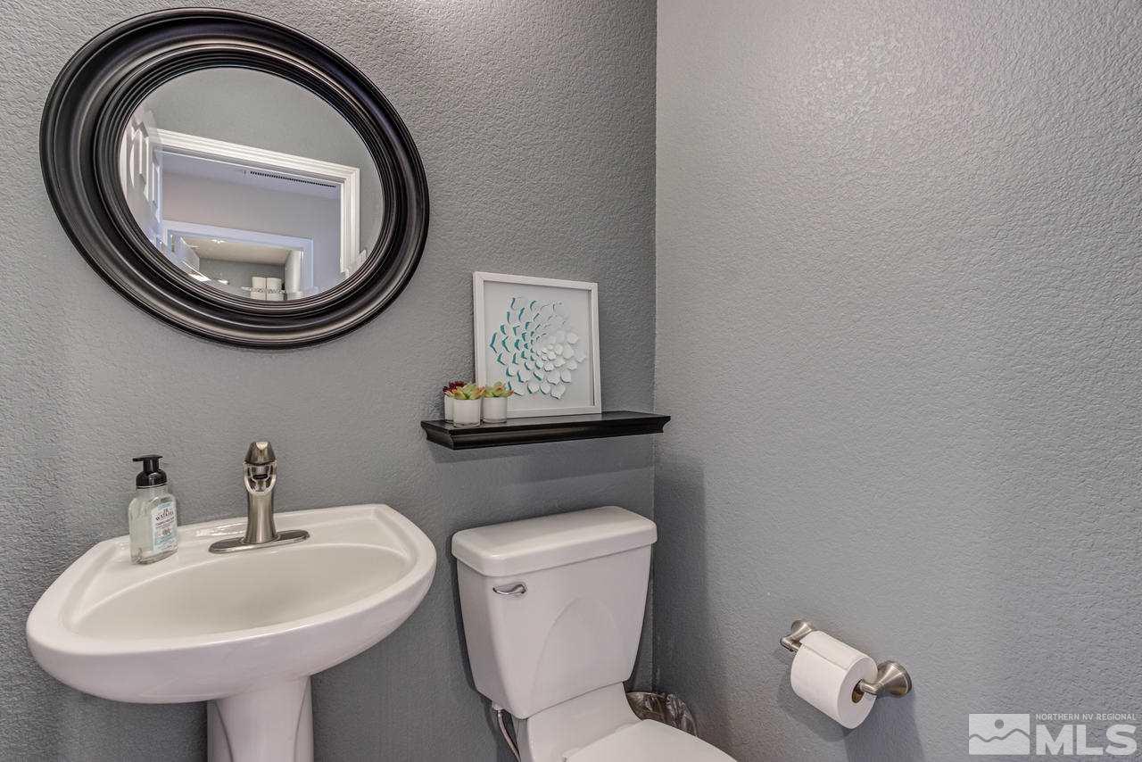 8921 Sorcha Street Reno, NV 89506 - Photo 29 of 35 a bathroom with a toilet a sink and a mirror