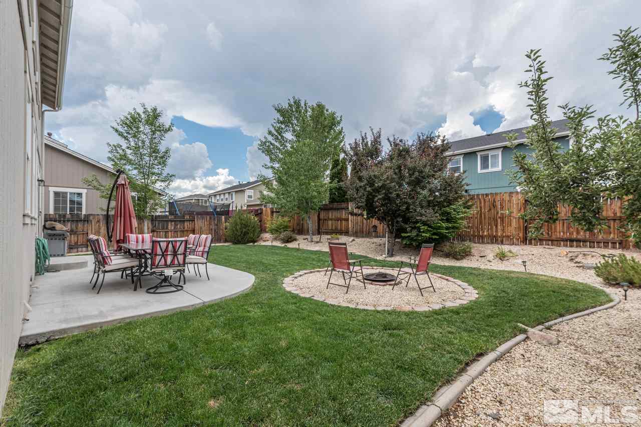 8921 Sorcha Street Reno, NV 89506 - Photo 34 of 35 a view of a patio with table and chairs potted plants and a large tree