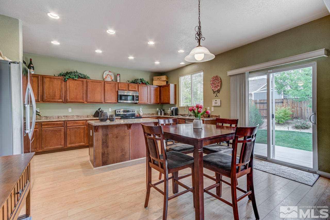 8921 Sorcha Street Reno, NV 89506 - Photo 9 of 35 a kitchen with stainless steel appliances granite countertop wooden cabinets a stove a sink a oven and a large window