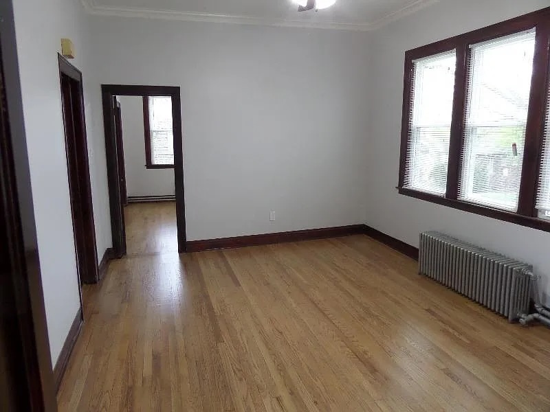 2836 East 84th Street Chicago, IL 60617 - Photo 5 of 7 a view of an empty room with wooden floor and a window