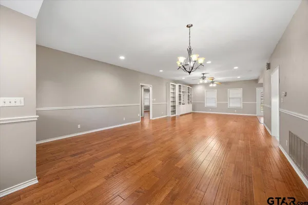 a view of a room with wooden floor and chandelier