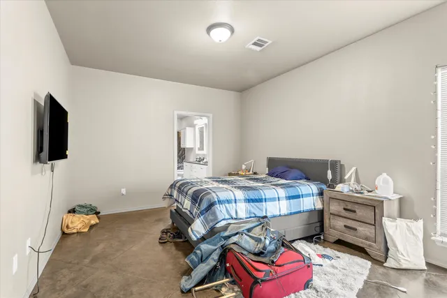 a bedroom with a bed and flat screen tv