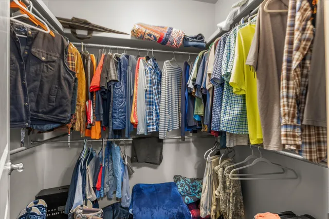 a view of walk in closet with clothes and shoes