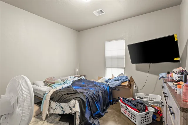 a bedroom with bed and a flat screen tv