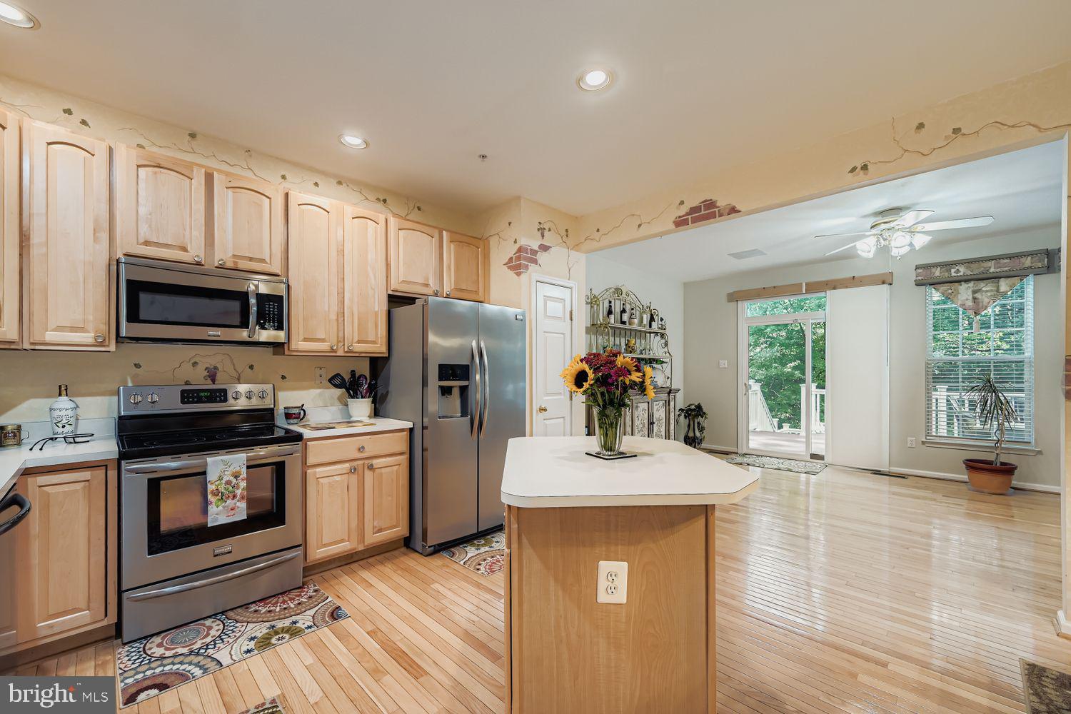 9809 Redwing Drive, Unit 9809 Perry Hall, MD 21128 - Photo 10 of 42 a kitchen with stainless steel appliances granite countertop a refrigerator stove microwave and sink