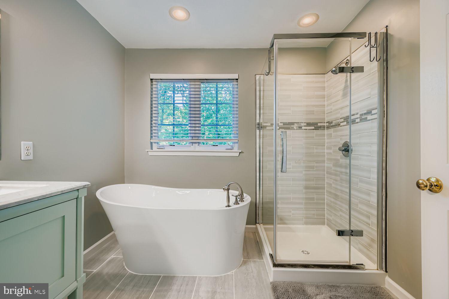 9809 Redwing Drive, Unit 9809 Perry Hall, MD 21128 - Photo 18 of 42 a white bath tub sitting next to a shower