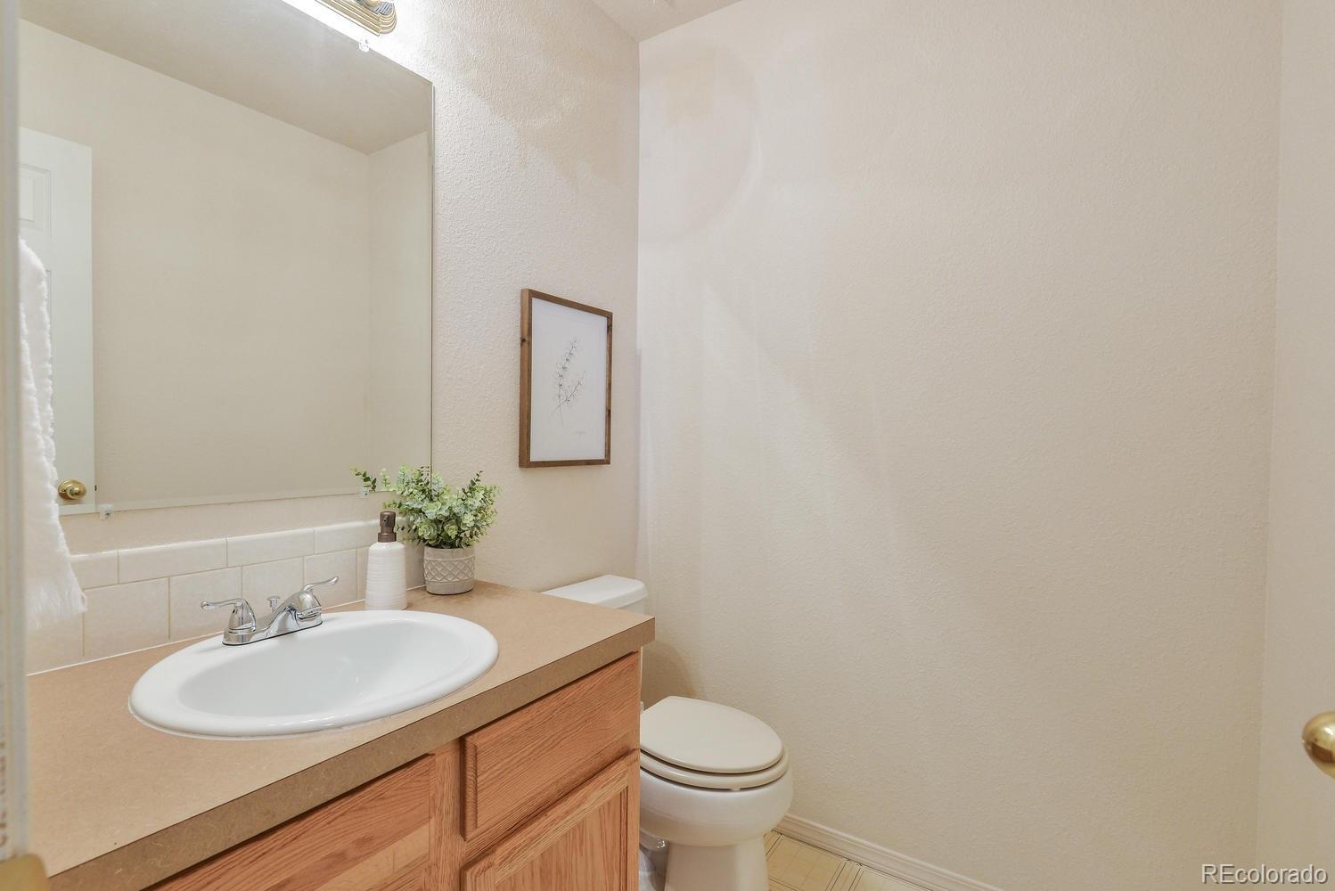 1437 Walnut Street Windsor, CO 80550 - Photo 12 of 35 a bathroom with a granite countertop sink and a mirror