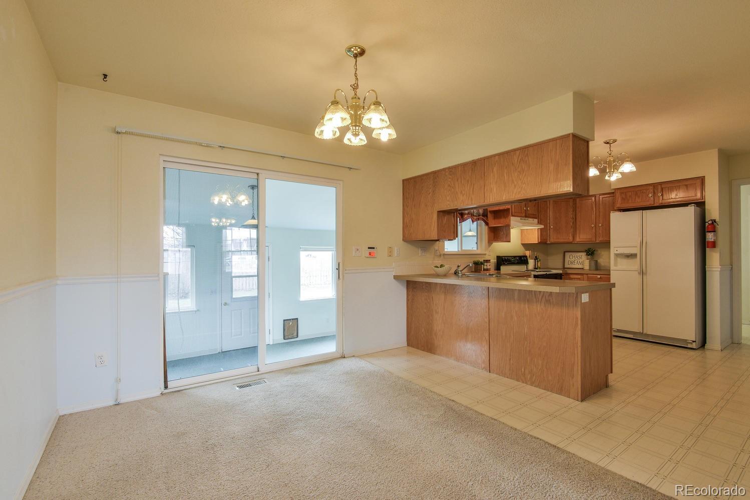 1437 Walnut Street Windsor, CO 80550 - Photo 7 of 35 a open kitchen with white cabinets and refrigerator