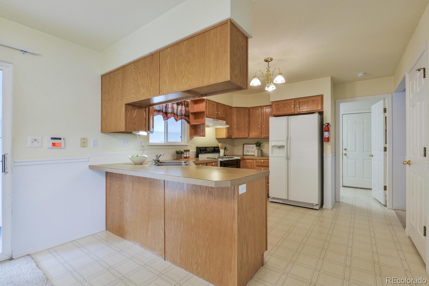 1437 Walnut Street Windsor, CO 80550 - Photo 9 of 35 a kitchen with refrigerator and cabinets