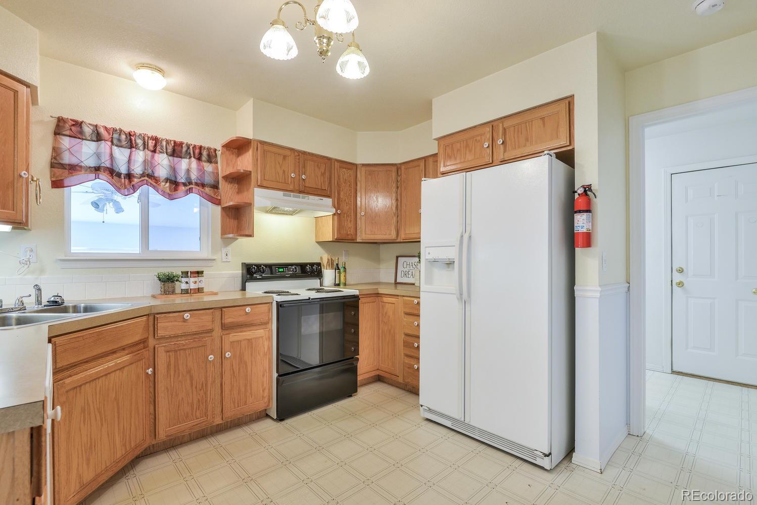 1437 Walnut Street Windsor, CO 80550 - Photo 10 of 35 a kitchen with stainless steel appliances granite countertop a refrigerator sink and stove