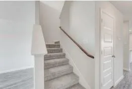 a view of staircase with white walls and white door