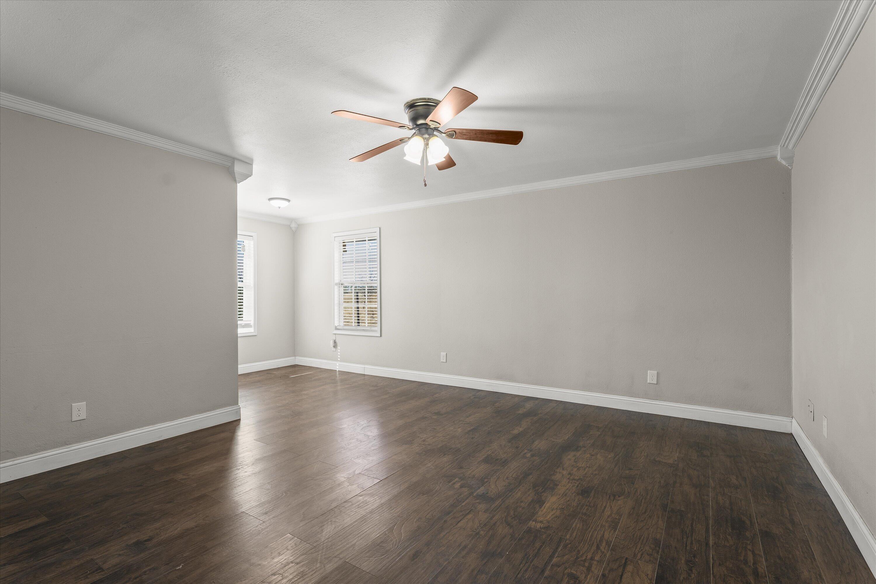 3131 North Alamo Road Levelland, TX 79336 - Photo 11 of 32 wooden floor in an empty room with a window