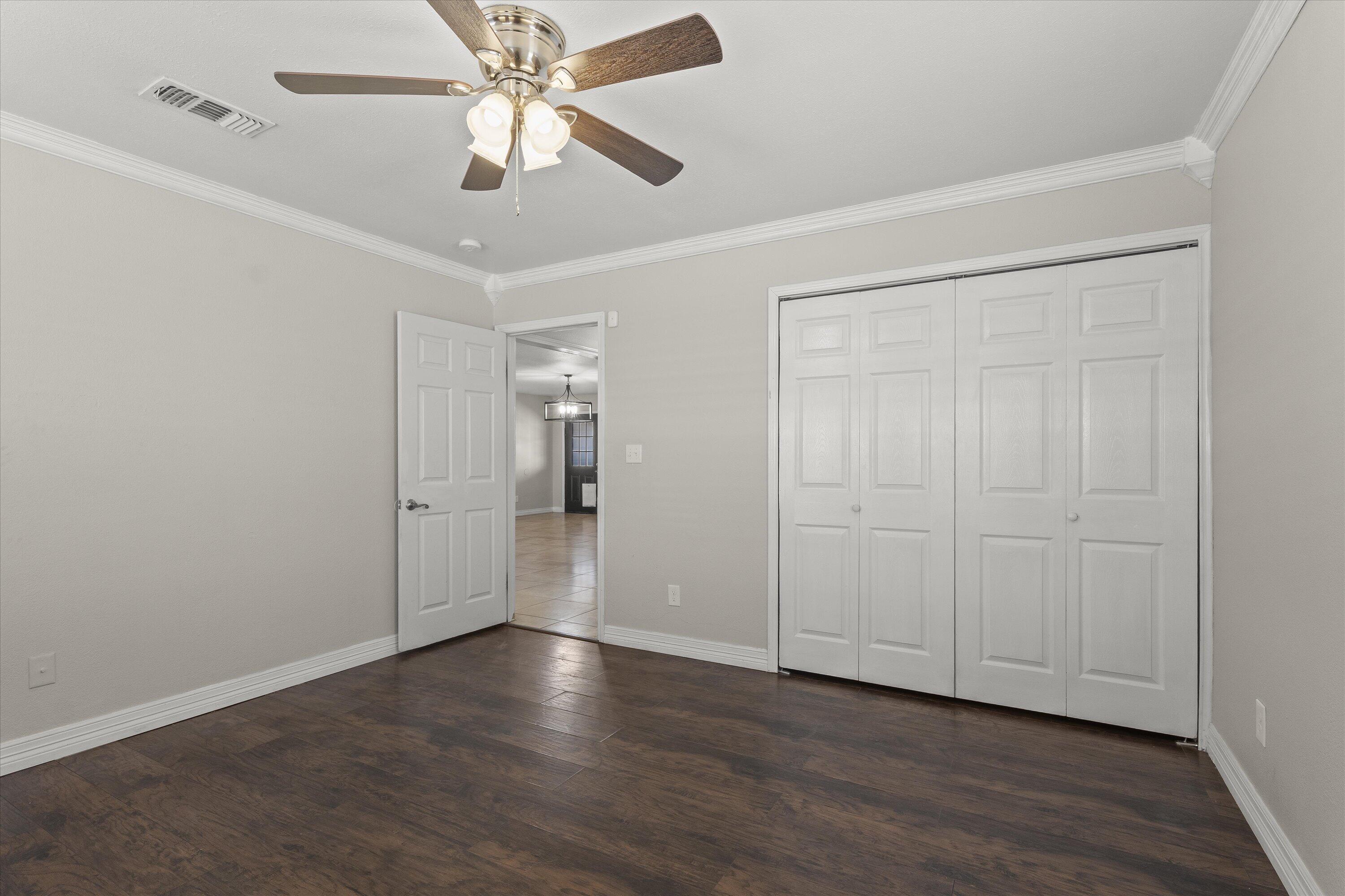 3131 North Alamo Road Levelland, TX 79336 - Photo 15 of 32 an empty room with wooden floor fan and windows