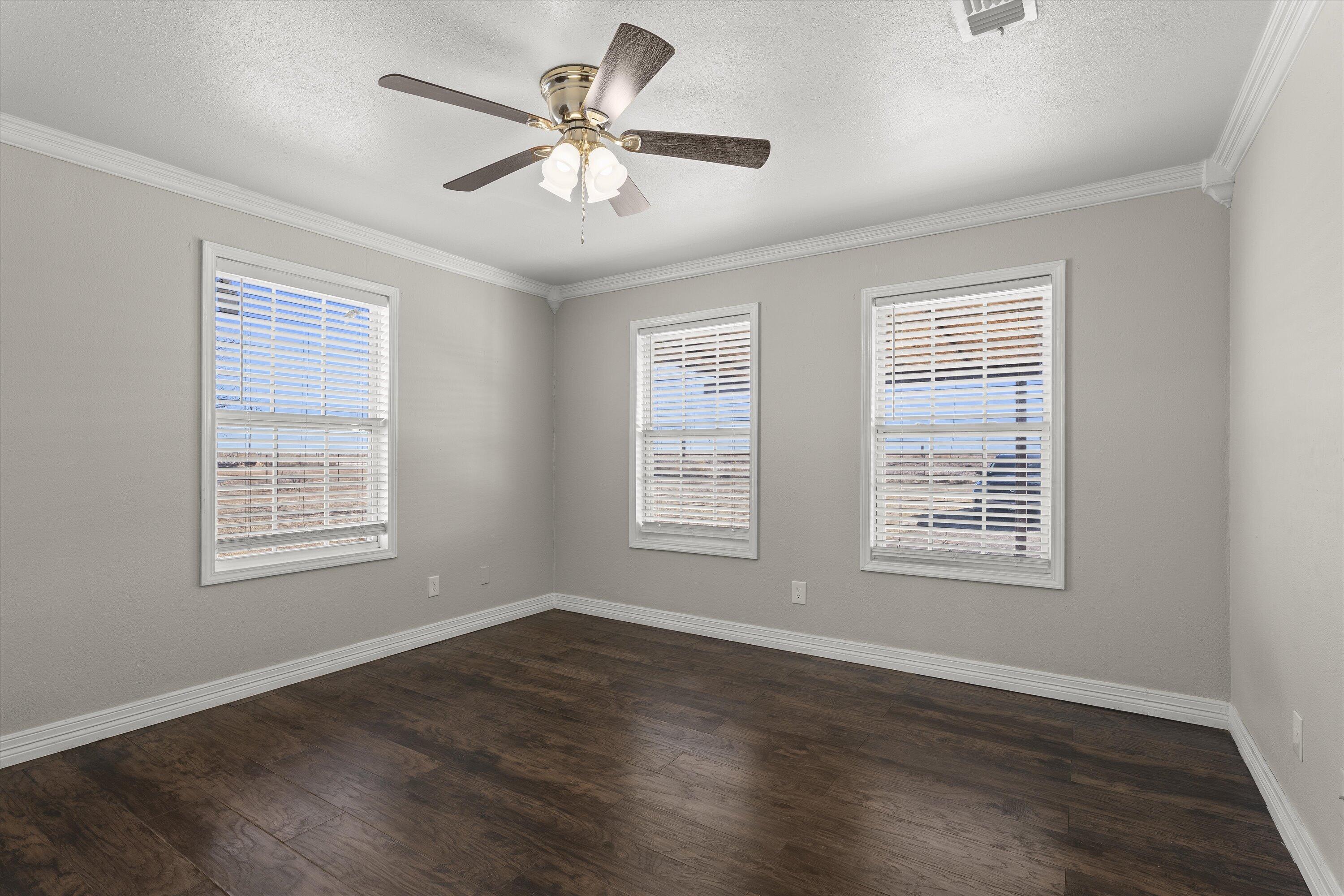 3131 North Alamo Road Levelland, TX 79336 - Photo 16 of 32 a view of an empty room with wooden floor and a window