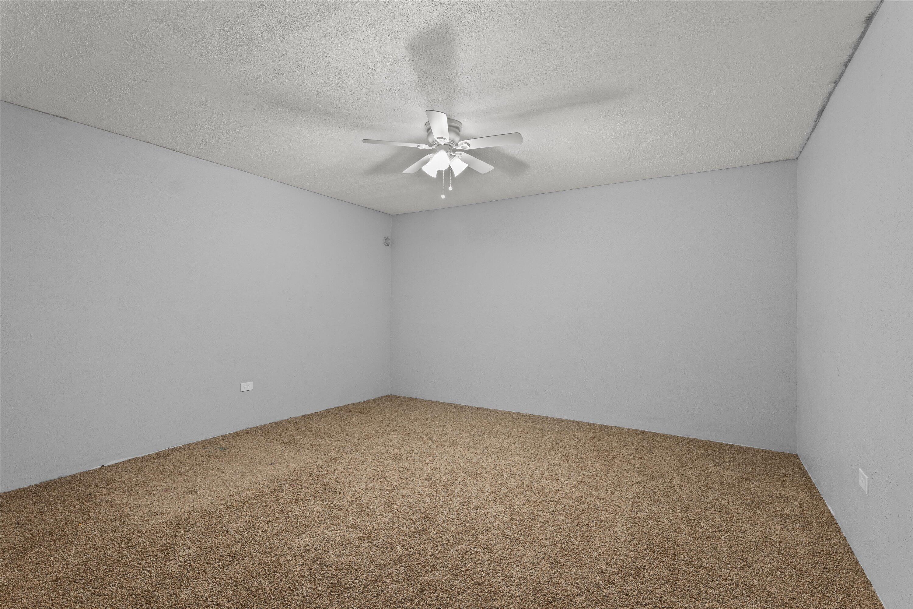3131 North Alamo Road Levelland, TX 79336 - Photo 22 of 32 an empty room with a chandelier fan and windows
