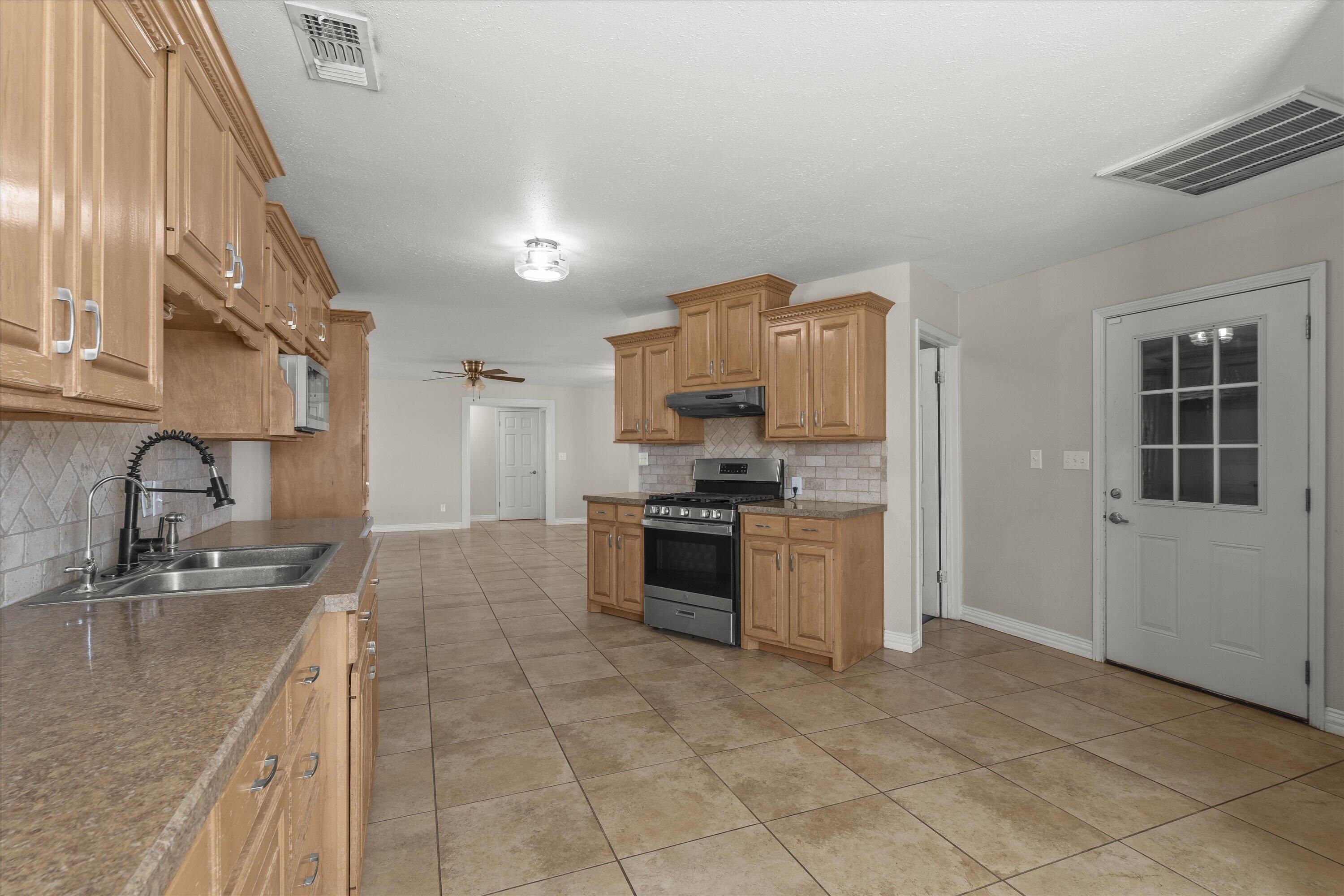 3131 North Alamo Road Levelland, TX 79336 - Photo 10 of 32 a kitchen with a sink cabinets and stainless steel appliances