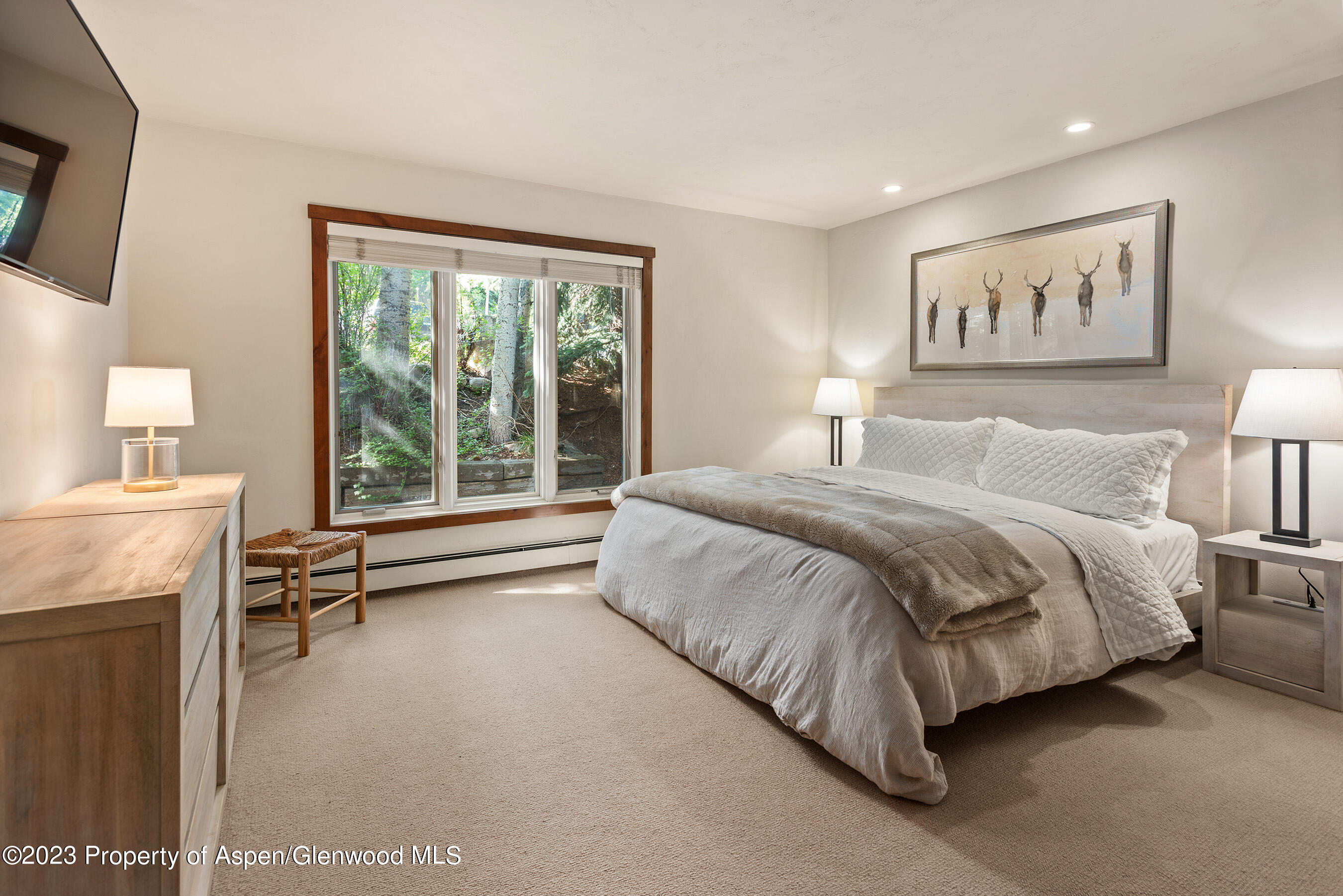 232 Meadow Ranch Road Snowmass Village, CO 81615 - Photo 10 of 18 a spacious bedroom with a bed a couch and a window