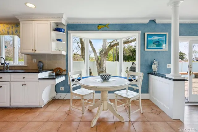 a kitchen with a dining table chairs and large window