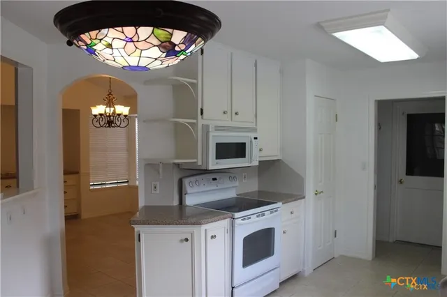 a kitchen with stainless steel appliances granite countertop a stove and a microwave