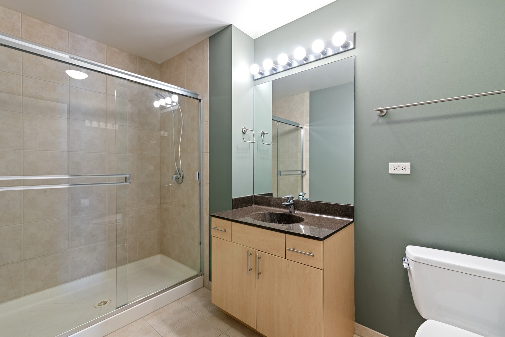 235 West Van Buren Street, Unit 2905 Chicago, IL 60607 - Photo 11 of 18 a bathroom with a granite countertop sink a toilet a mirror and shower