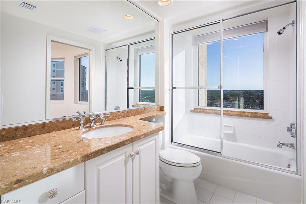 435 Dockside Drive, Unit B703 Naples, FL 34110 - Photo 25 of 38 a bathroom with a granite countertop sink toilet and shower