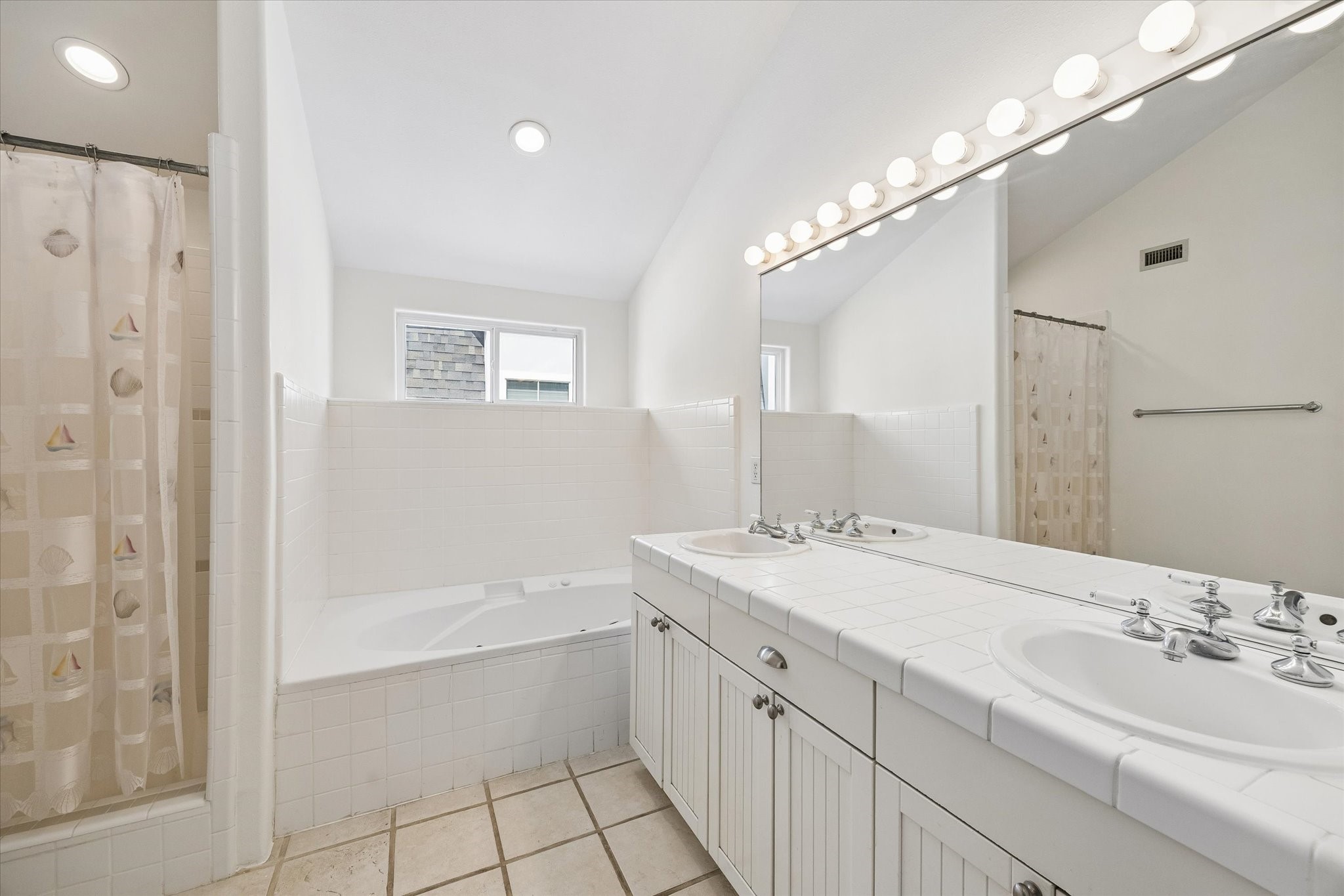 4011 Garrott Street Houston, TX 77006 - Photo 15 of 19 a bathroom with a bathtub a double vanity sink and mirror
