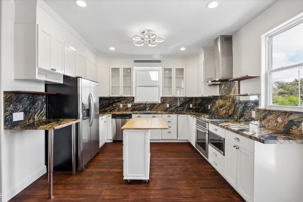 a kitchen with white cabinets and appliances