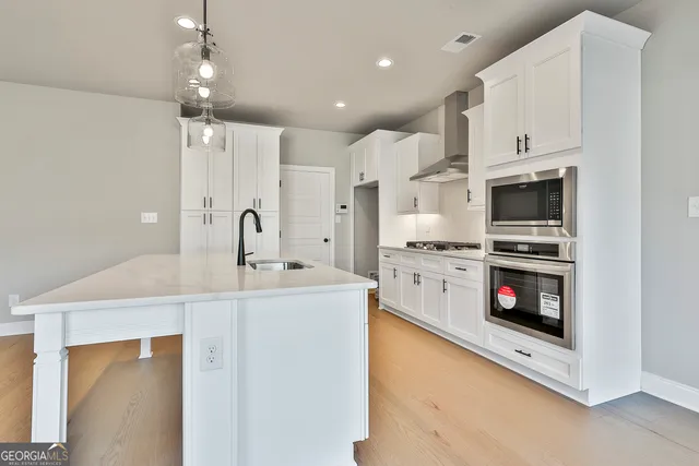 a kitchen with stainless steel appliances a stove sink and microwave