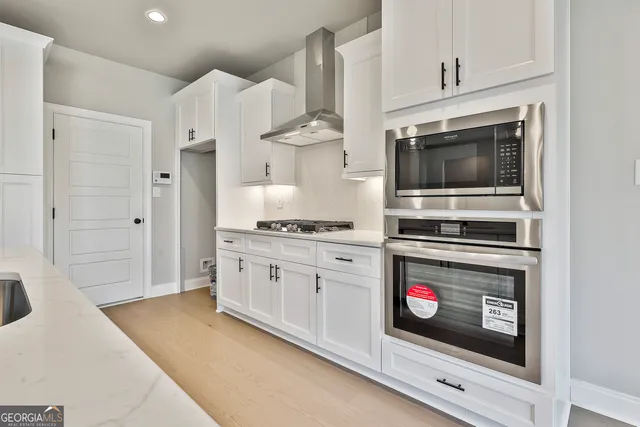 a kitchen with stainless steel appliances a stove a microwave and cabinets
