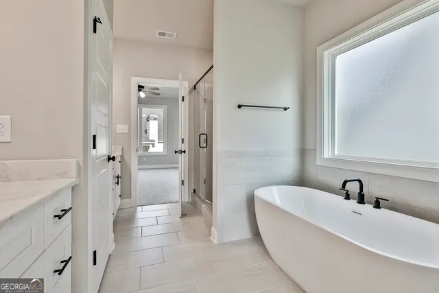a bathroom with a tub sink shower and mirror