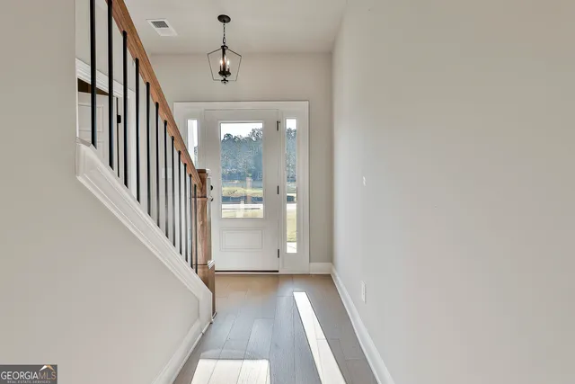 a view of a hallway with wooden floor and staircase