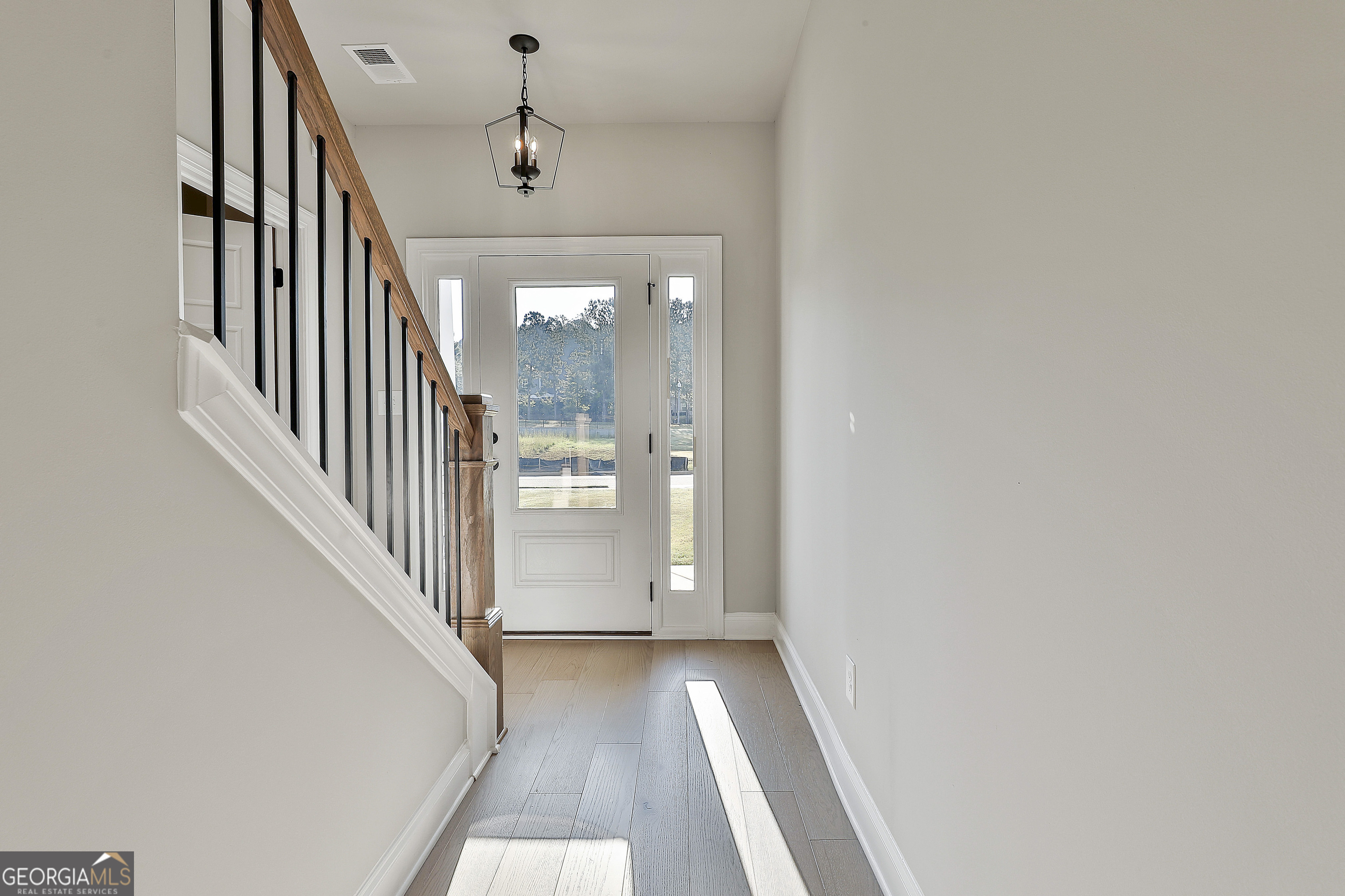 6 Leverett Drive, Unit 17 Newnan, GA 30265 - Photo 5 of 35 a view of a hallway with wooden floor and staircase