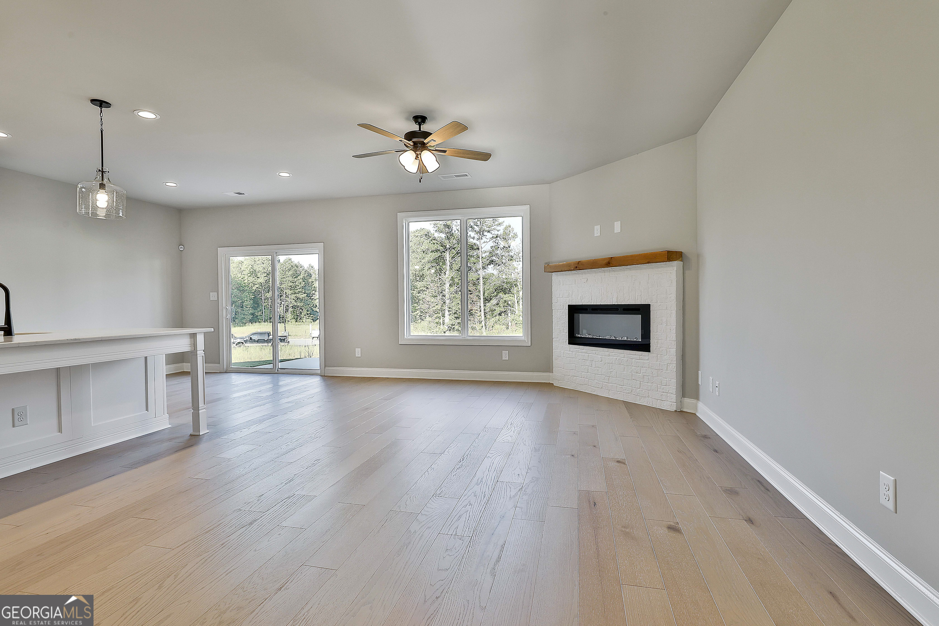 6 Leverett Drive, Unit 17 Newnan, GA 30265 - Photo 8 of 35 an empty room with wooden floor fireplace and windows