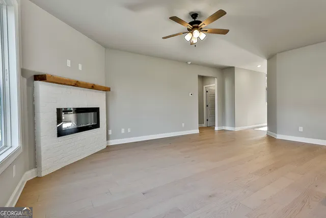 a view of a room with a ceiling fan and a fireplace