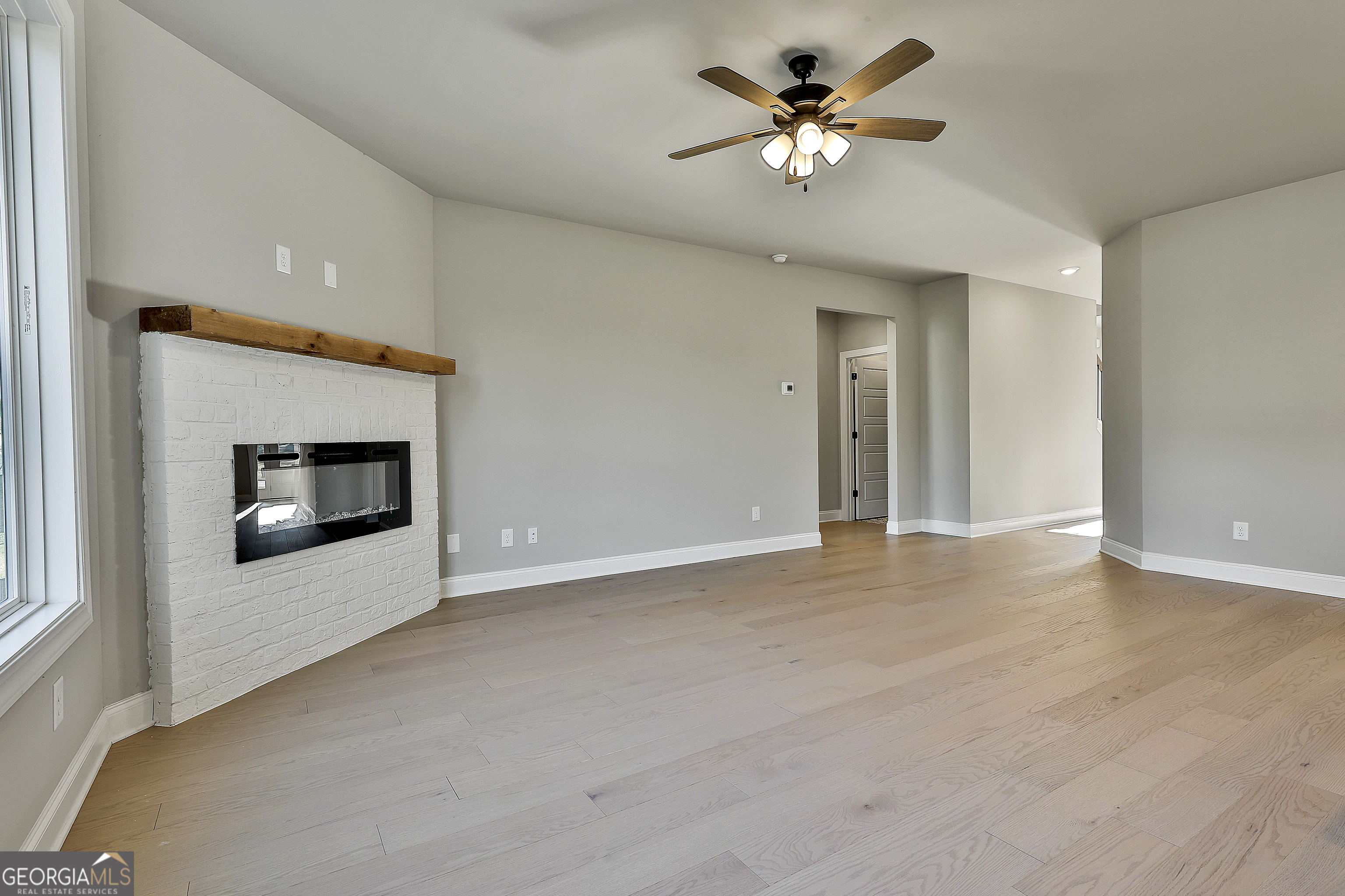 6 Leverett Drive, Unit 17 Newnan, GA 30265 - Photo 10 of 35 a view of a room with a ceiling fan and a fireplace