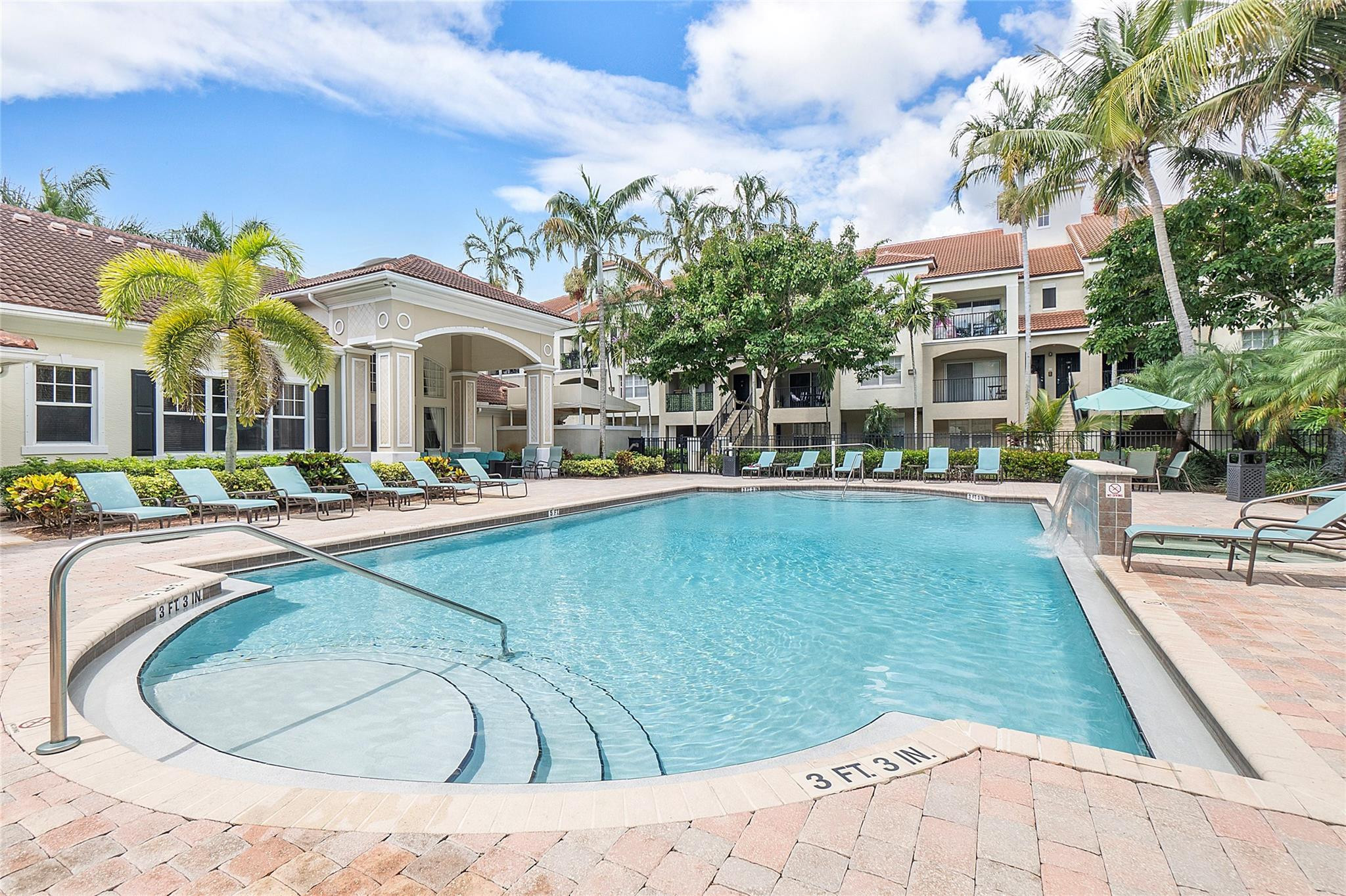 6020 West Sample Road, Unit 103 Coral Springs, FL 33067 - Photo 16 of 20 a view of a swimming pool with a bench and trees in the background