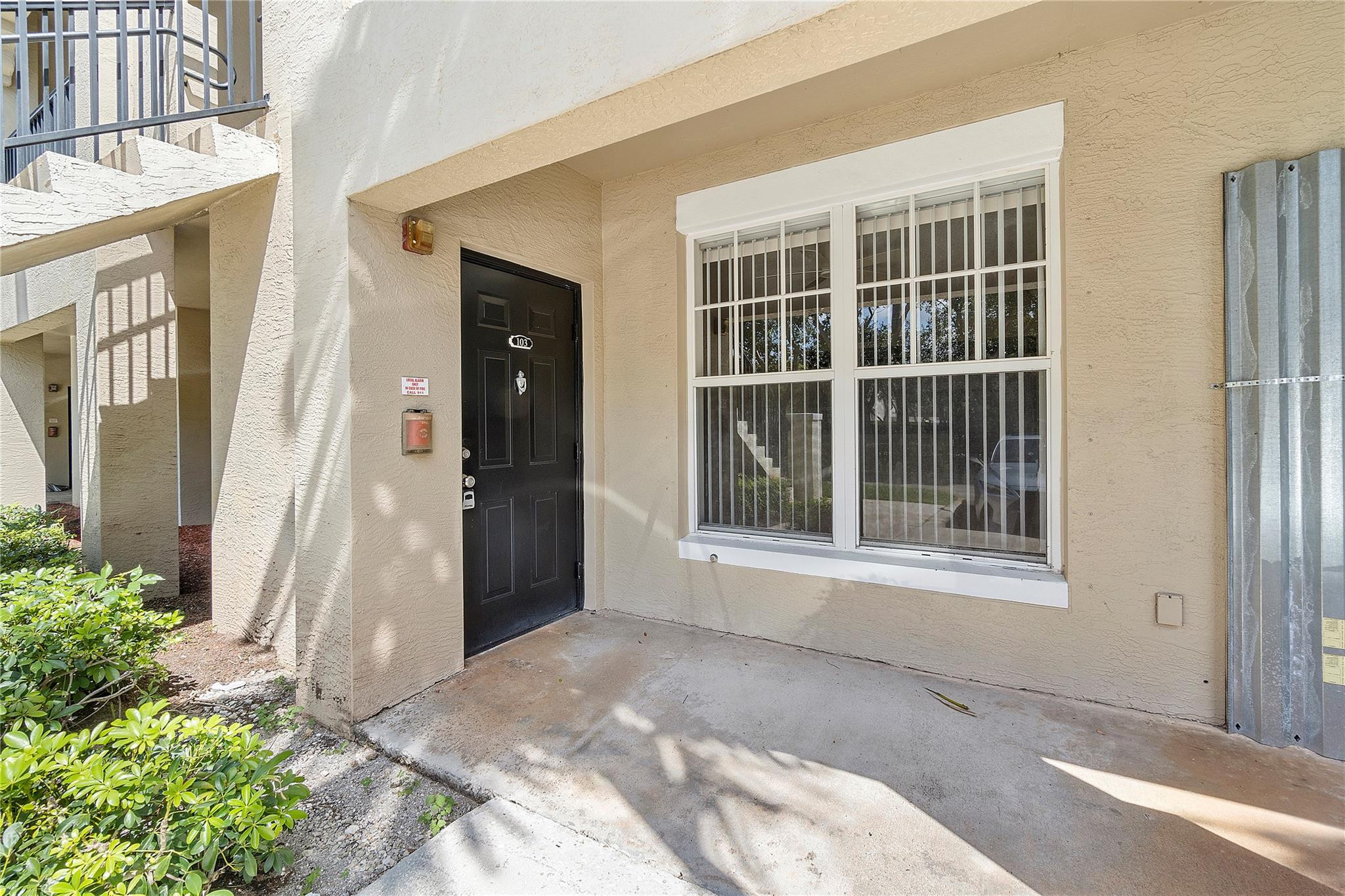 6020 West Sample Road, Unit 103 Coral Springs, FL 33067 - Photo 2 of 20 a view of a house with a backyard and balcony