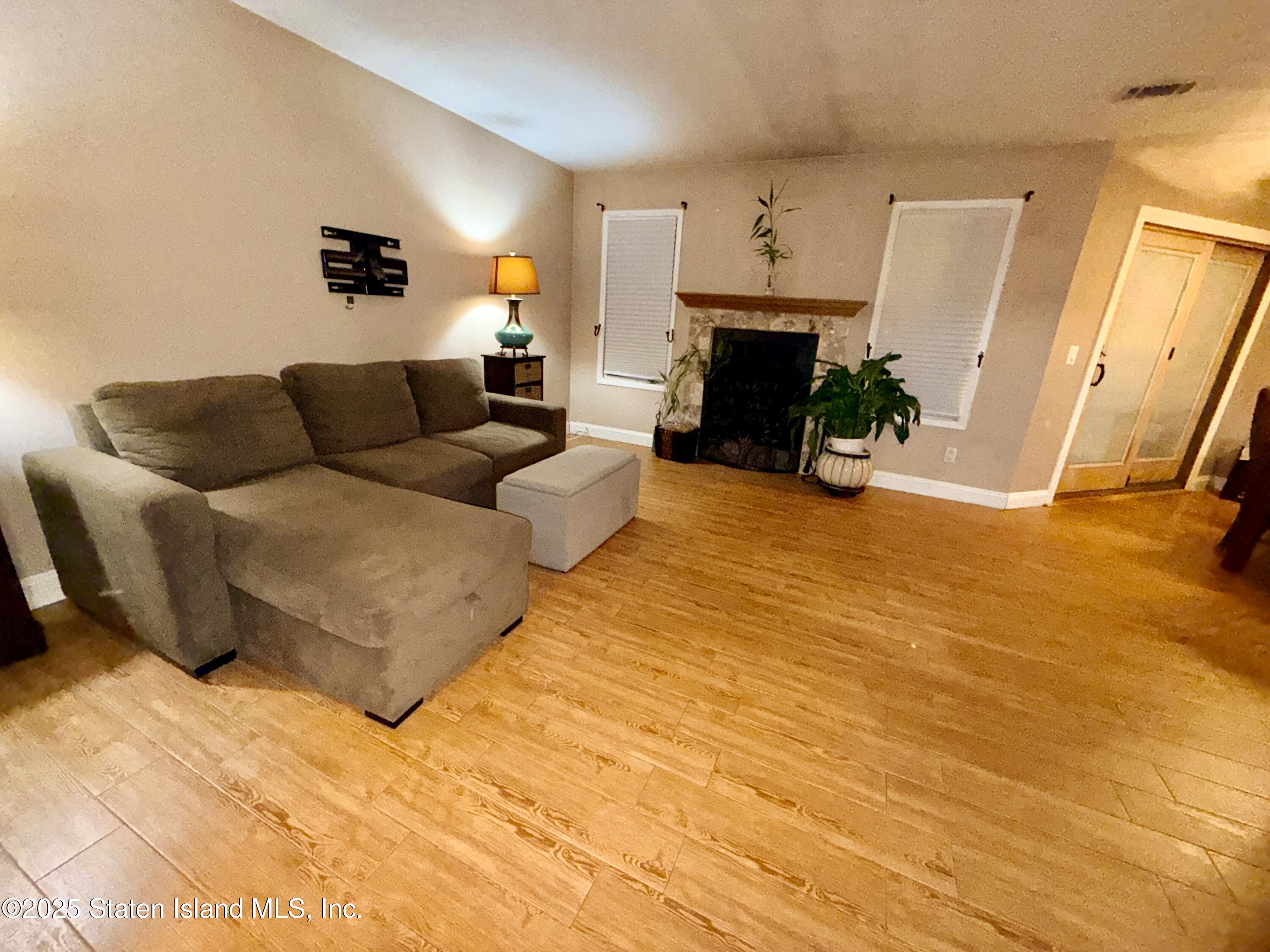 1446 Forest Hill Road, Unit 4 Staten Island, NY 10314 - Photo 13 of 24 a living room with furniture and a fireplace