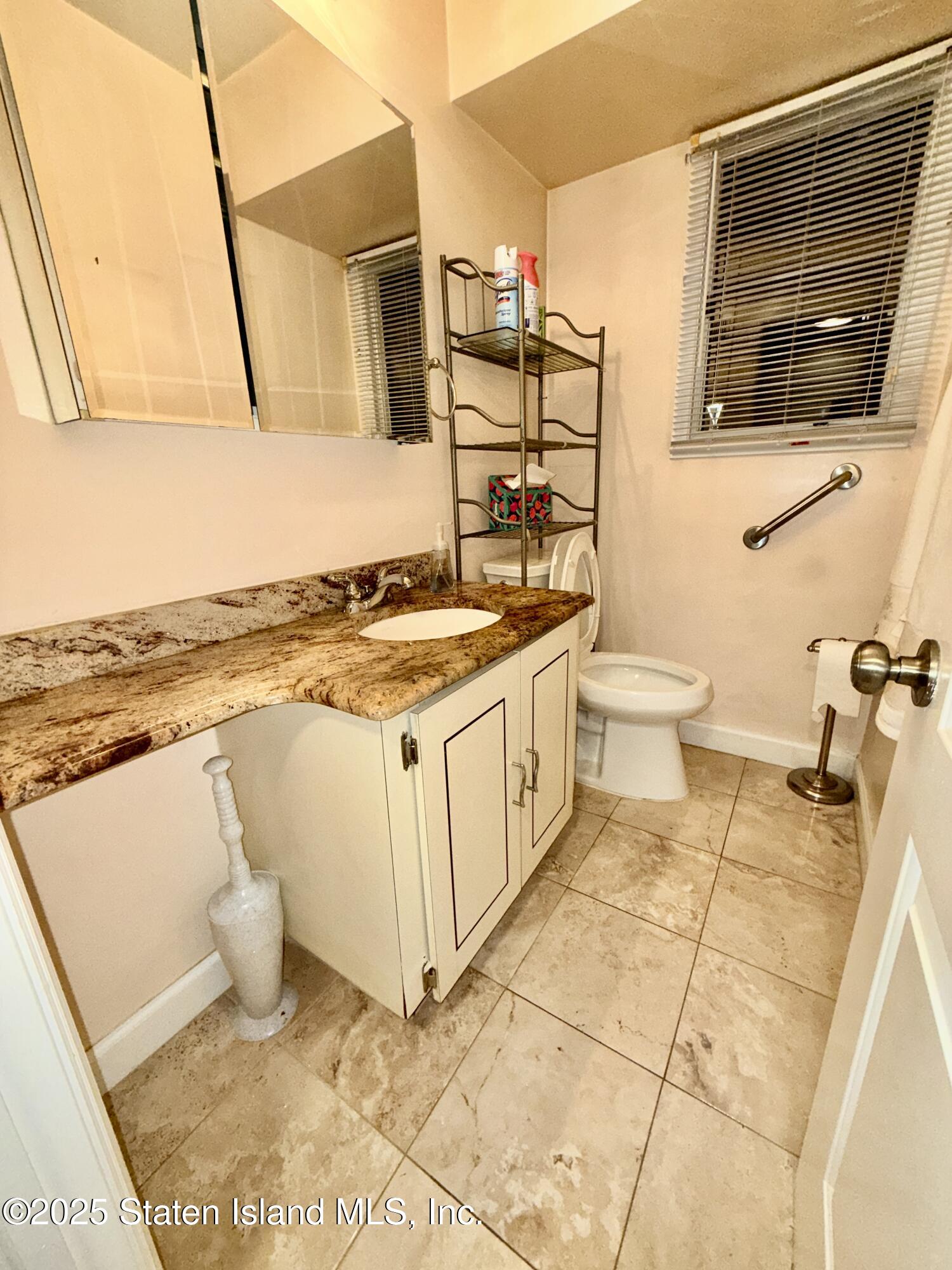 1446 Forest Hill Road, Unit 4 Staten Island, NY 10314 - Photo 16 of 24 a bathroom with a toilet a sink and a mirror