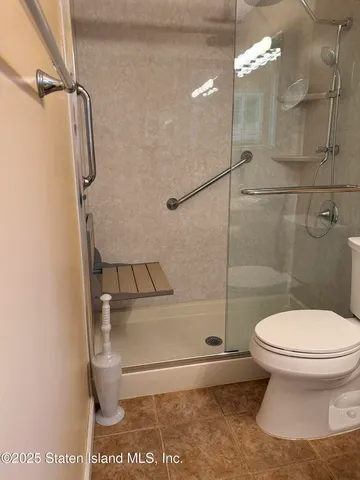 a bathroom with a toilet and a shower