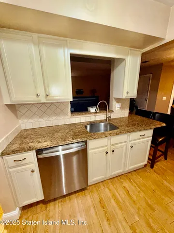 a kitchen with granite countertop a sink stove and cabinets